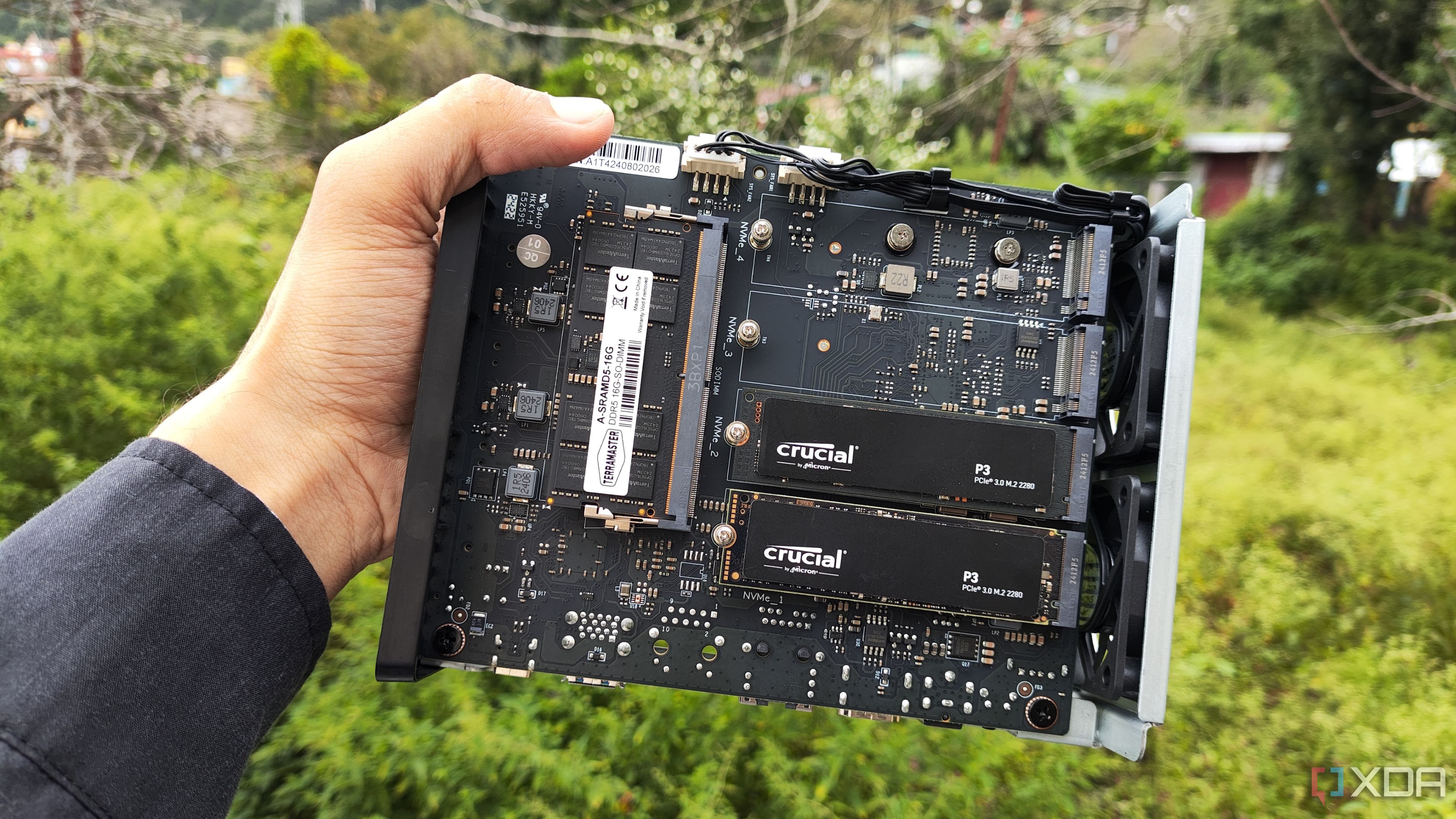 Una persona sostiene un TerraMaster F8 SSD Plus, con dos SSD PCIe 3 insertados en el NAS