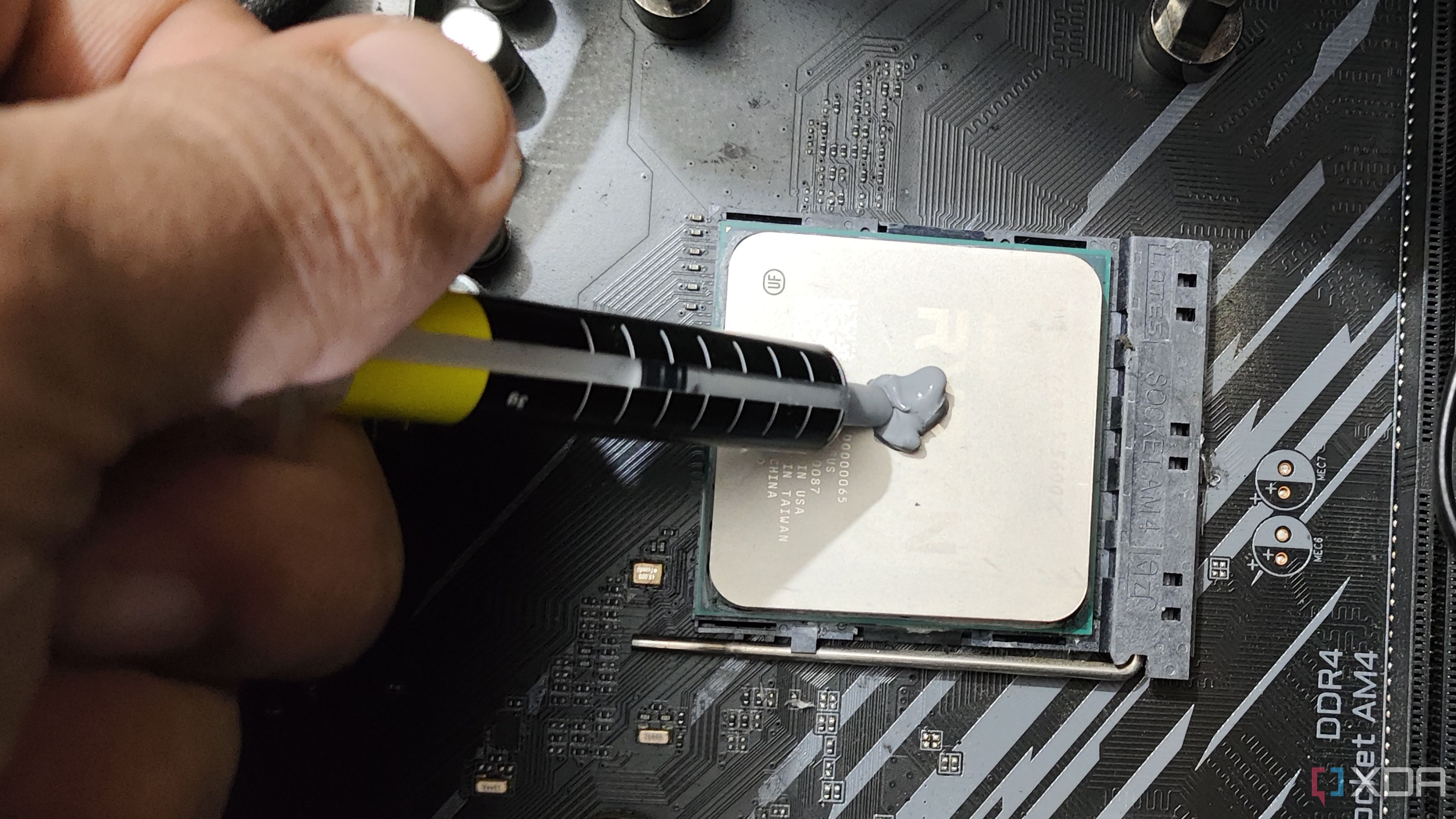 Una persona aplicando pasta térmica en un Ryzen 5 5600X