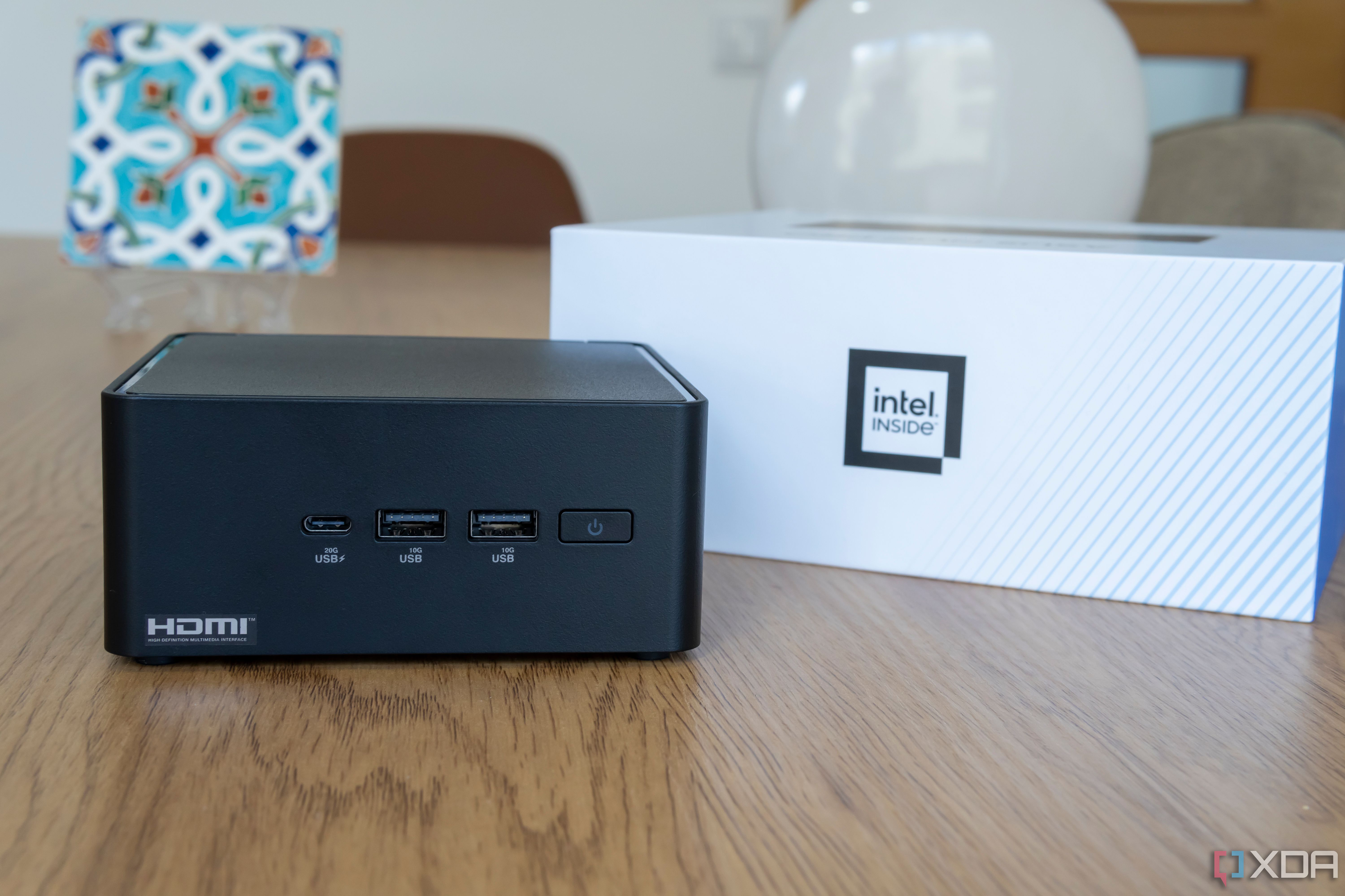 Vista frontal del Asus NUC 14 Pro junto a una caja con un logotipo que dice Intel Inside