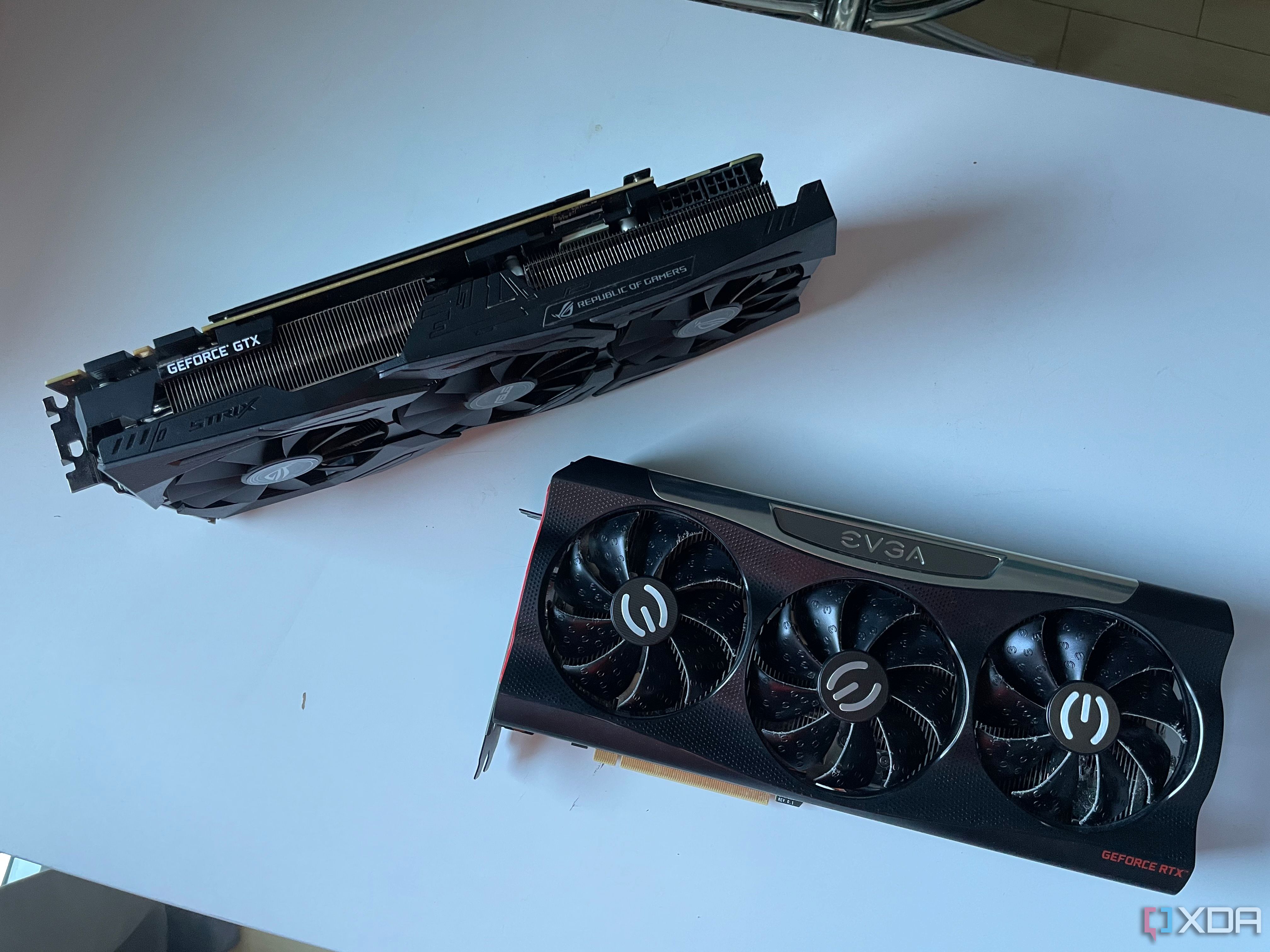 Una foto de una ASUS STRIX 1080ti y una EVGA RTX 3080 colocadas sobre una mesa.