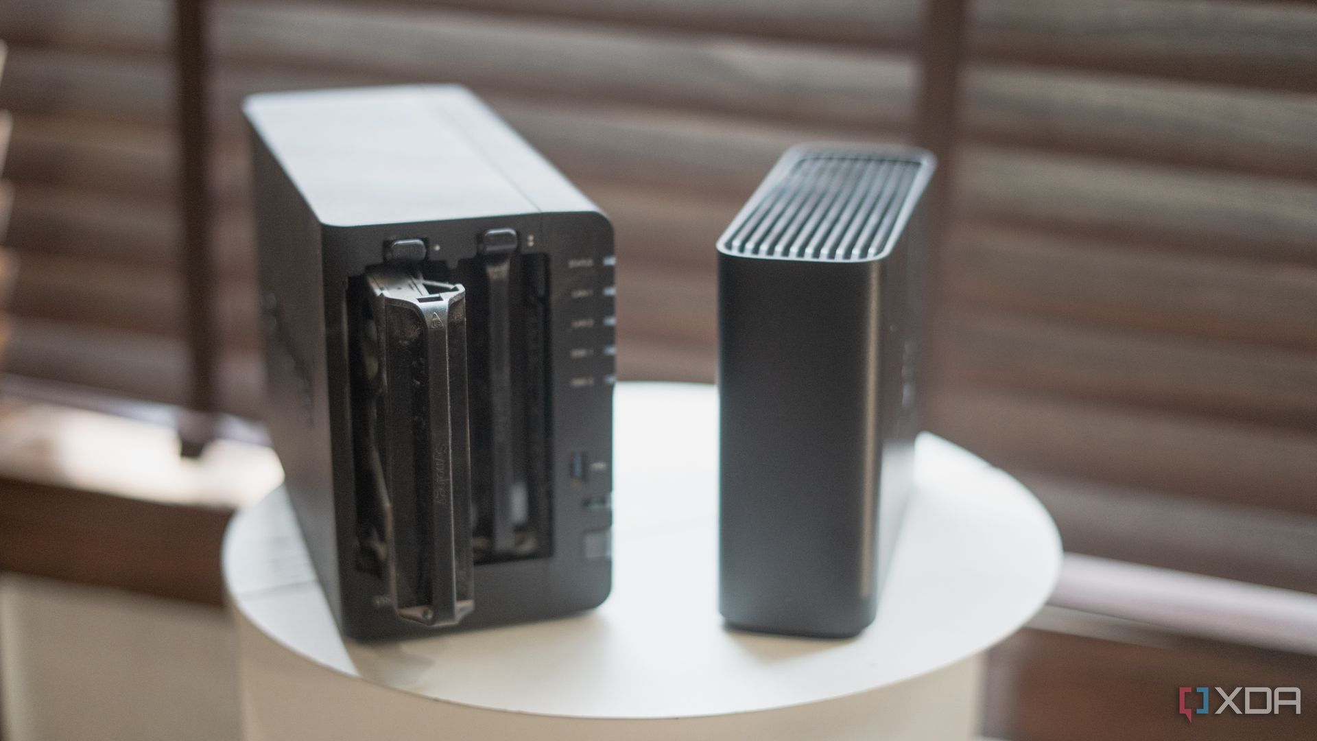 Comparación entre la unidad Synology Beestation y la NAS, que muestra la bandeja de la unidad colocada sobre una mesa