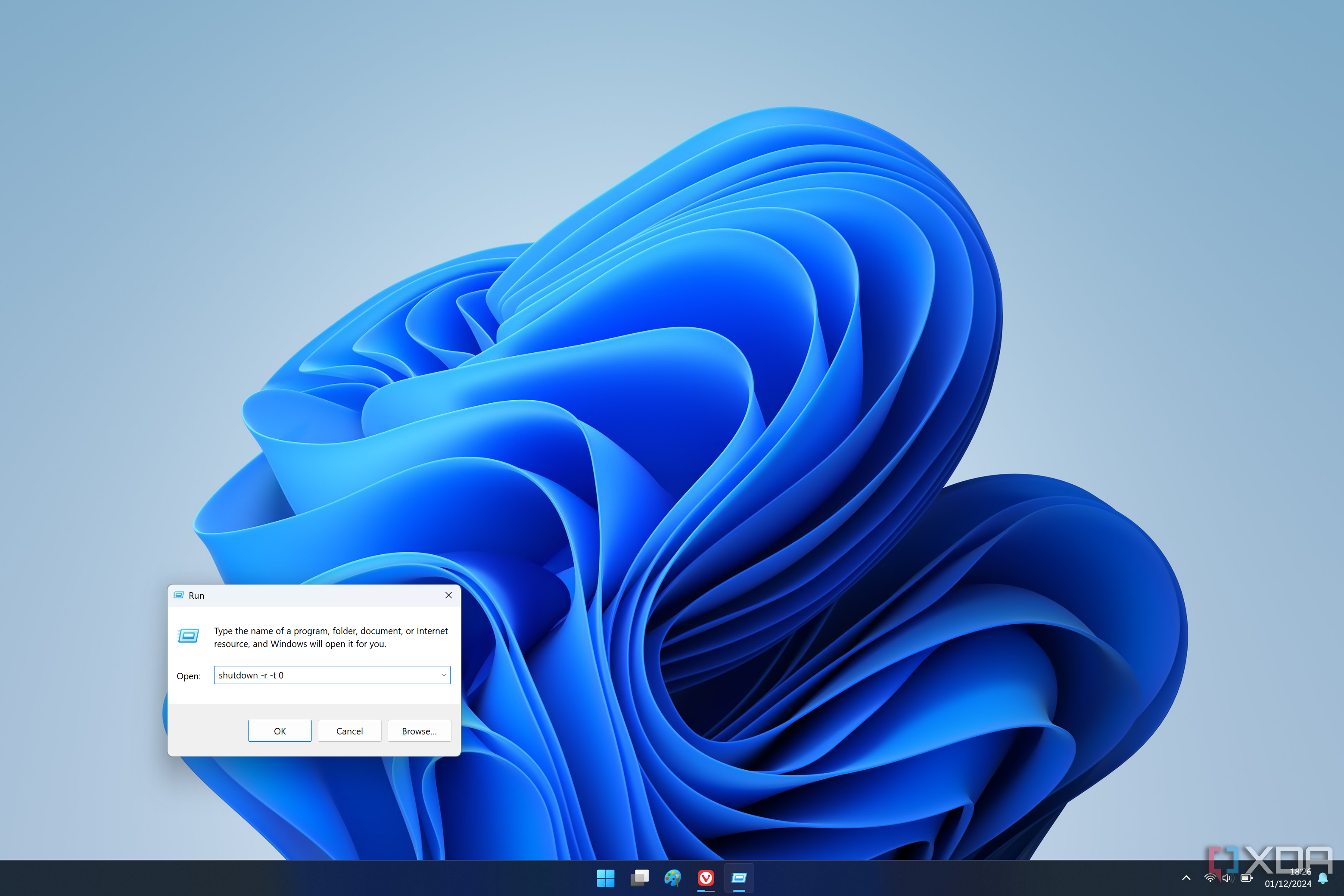 Captura de pantalla de un escritorio de Windows 11 con el cuadro de diálogo Ejecutar que contiene un comando para reiniciar la PC