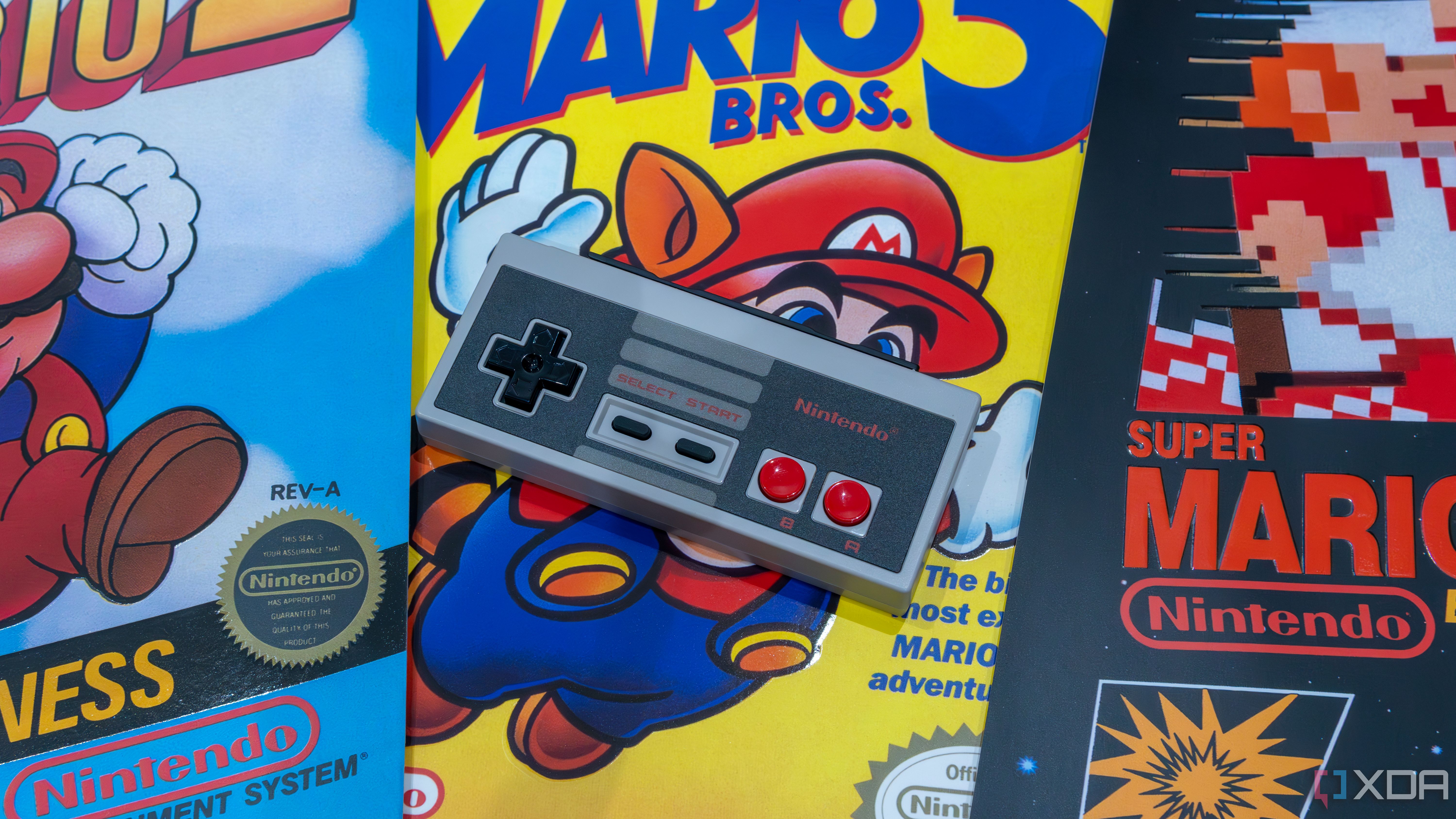 Un controlador de réplica de NES para Nintendo Switch sobre carteles de varios juegos de Mario