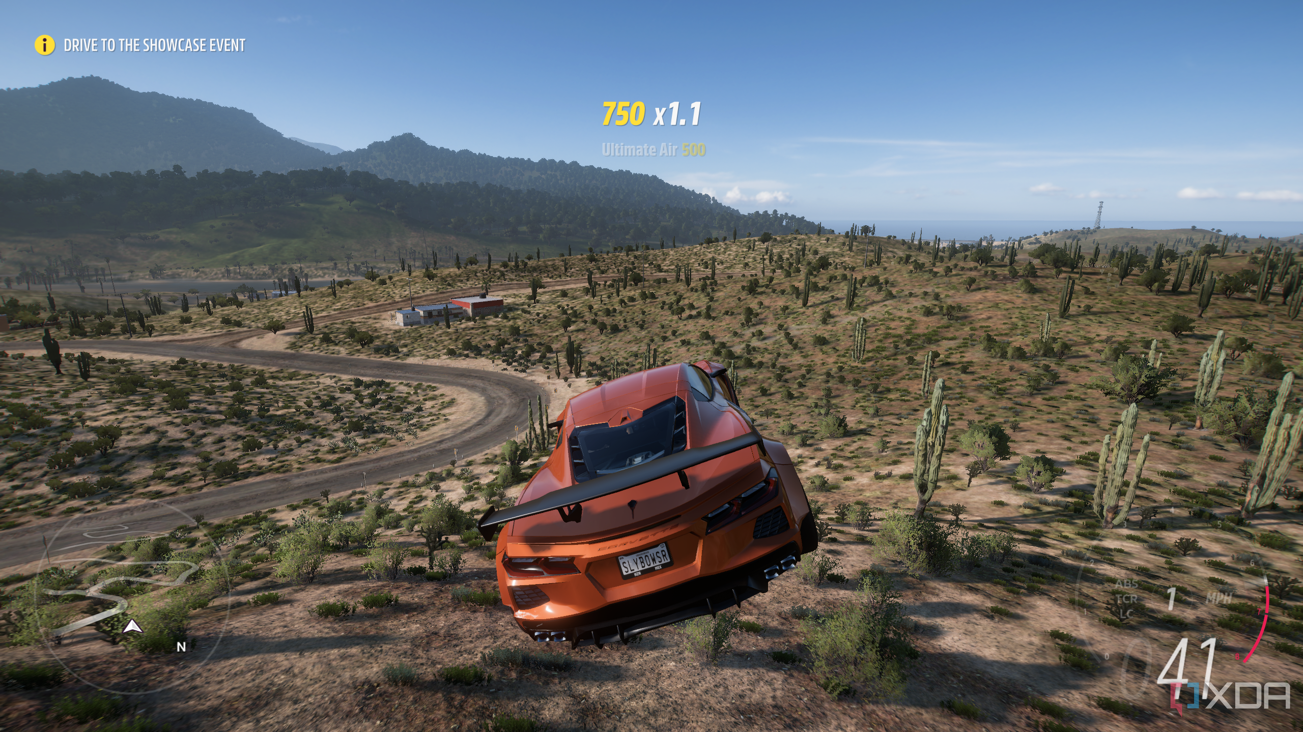 Captura de pantalla del videojuego Forza Horizon 5 de un automóvil naranja volando por el aire en una escena desértica.