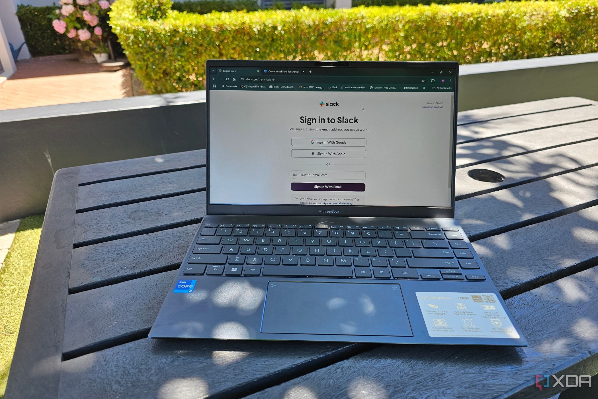 Una computadora portátil afuera sobre una mesa que muestra una pantalla de inicio de sesión de Slack