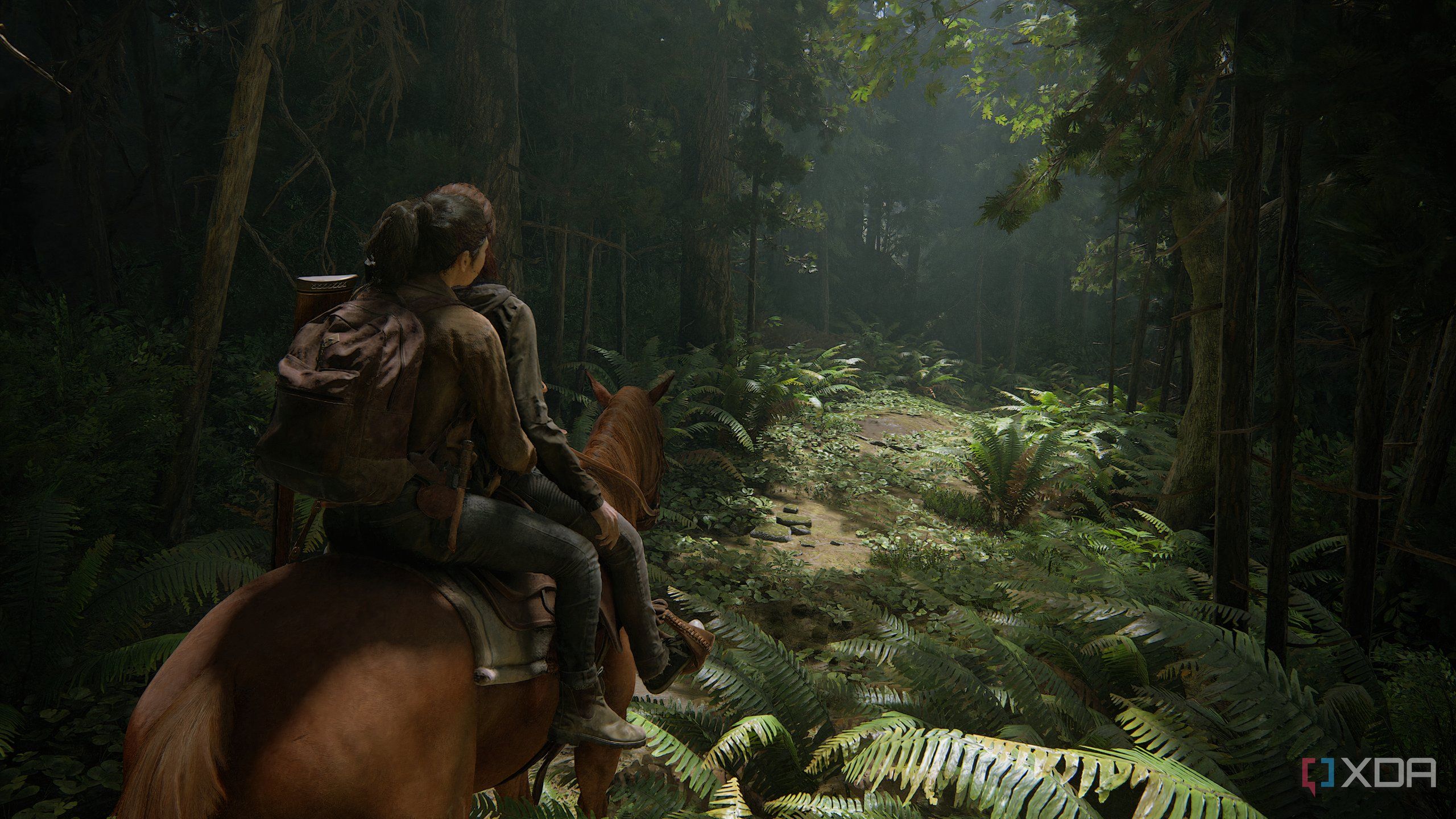 A screenshot from the game The Last of Us Part II Remastered on PC, showing Ellie and Dina on horseback, riding through a lush forest.