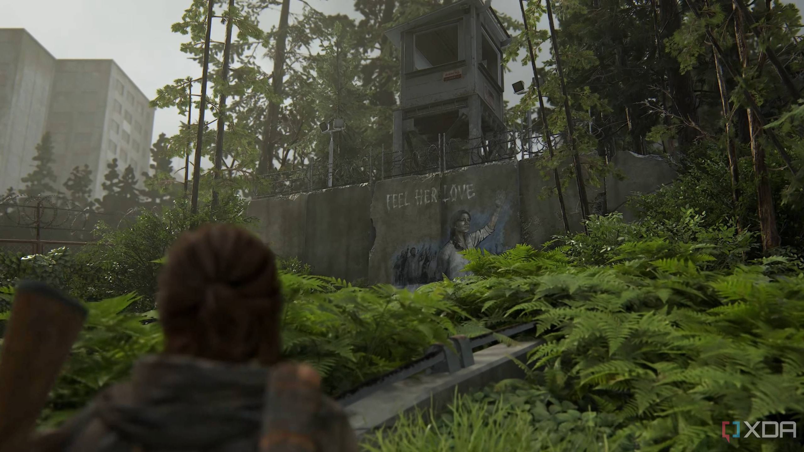 Ellie looking at a Seraphite mural in The Last of Us Part II Remastered.