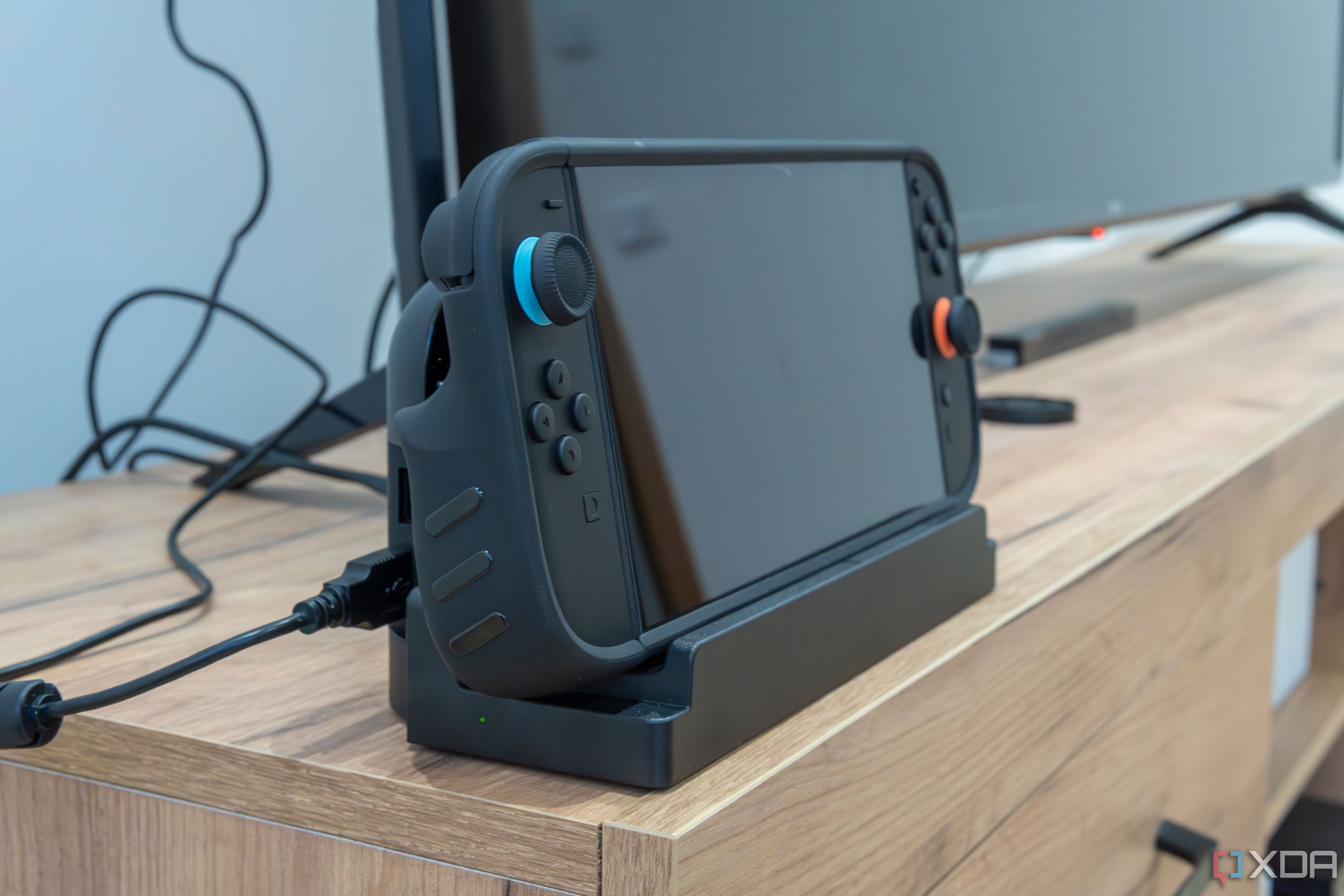 Vista en ángulo de un Nintendo Switch 2 usando la caja de agarre Killswitch establecida en el adaptador de muelle para ser utilizado en modo TV