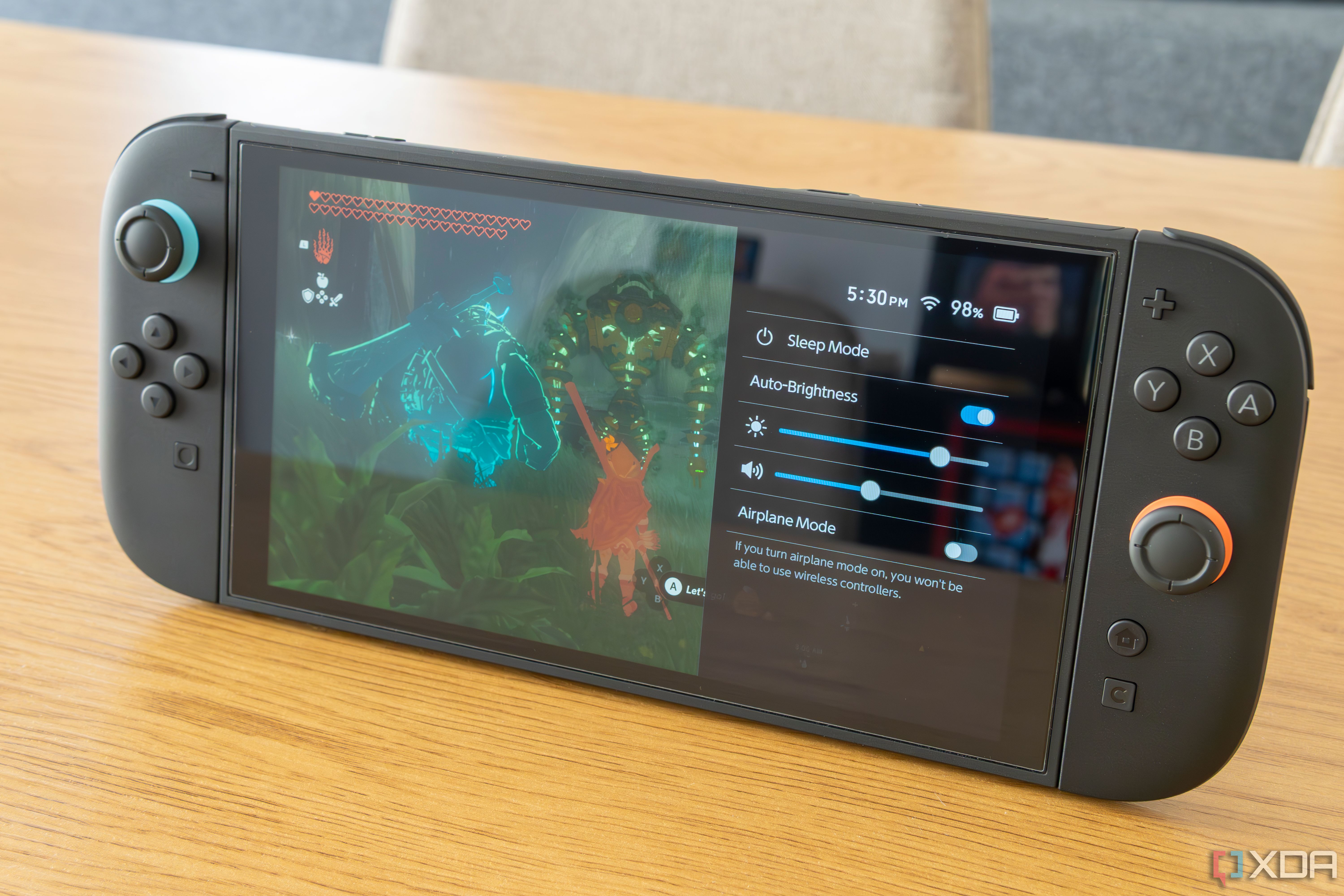 A Nintendo Switch 2 console standing up and showing the battery overlay over The Legend of Zelda Tears of the Kingdom