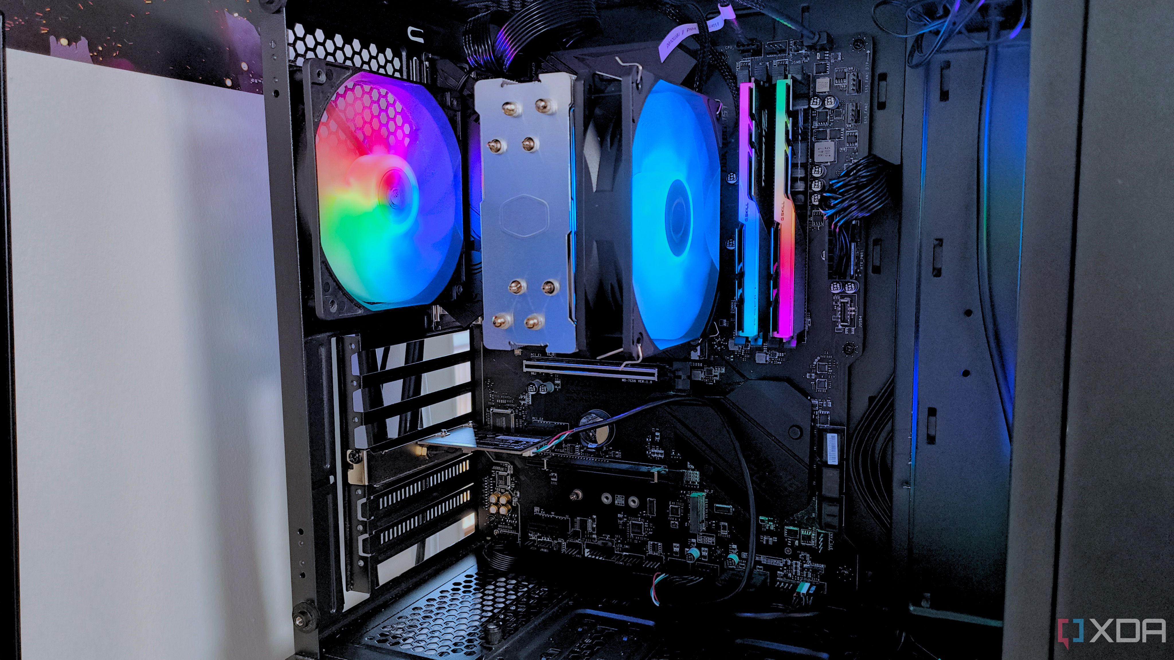 A close up of the interior of a black gaming PC with rainbow RGB fans