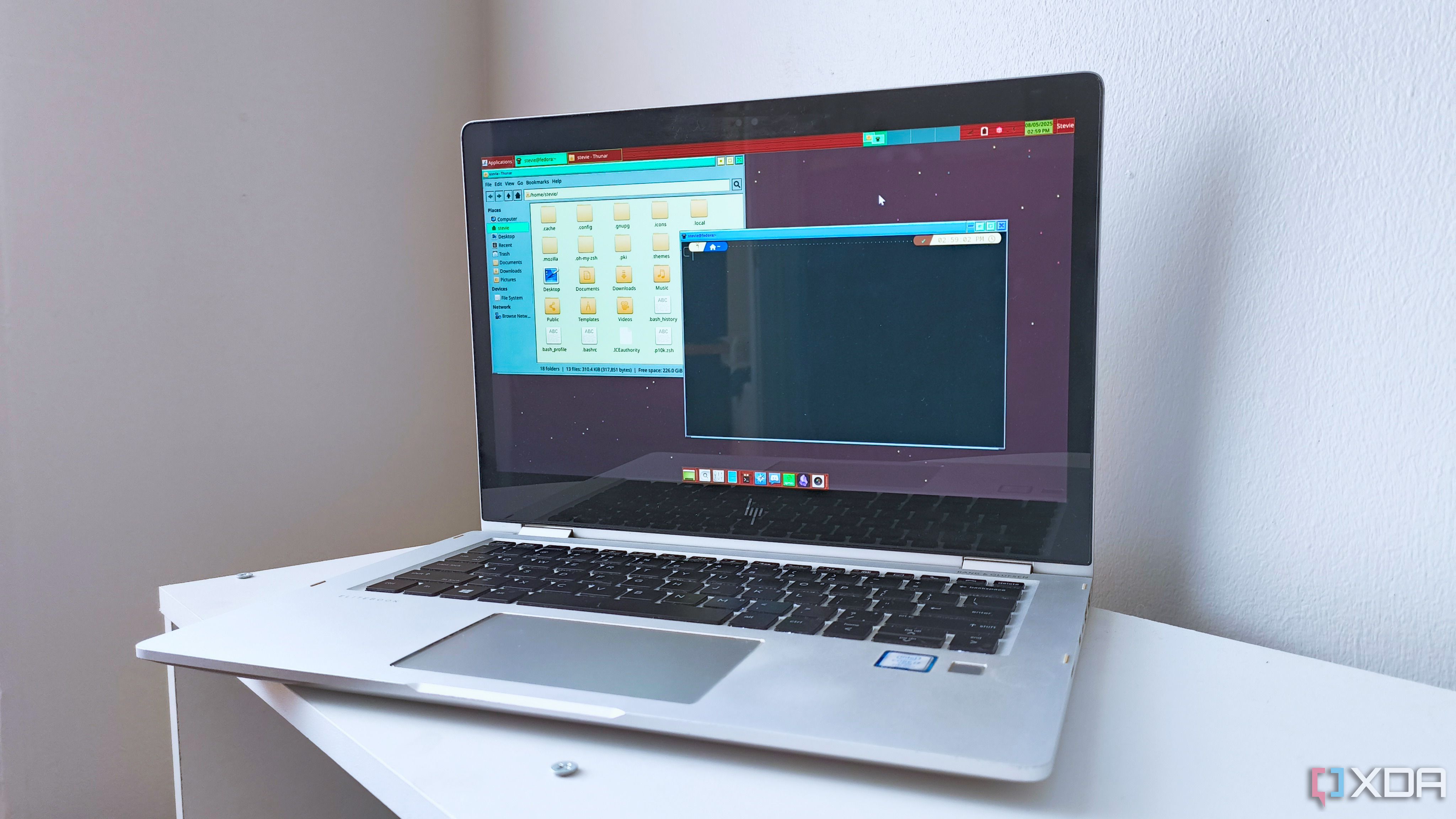 A 2017 HP EliteBook x360 1030 G2 running Fedora 42 with the XFCE desktop environment and a retro panel theme
